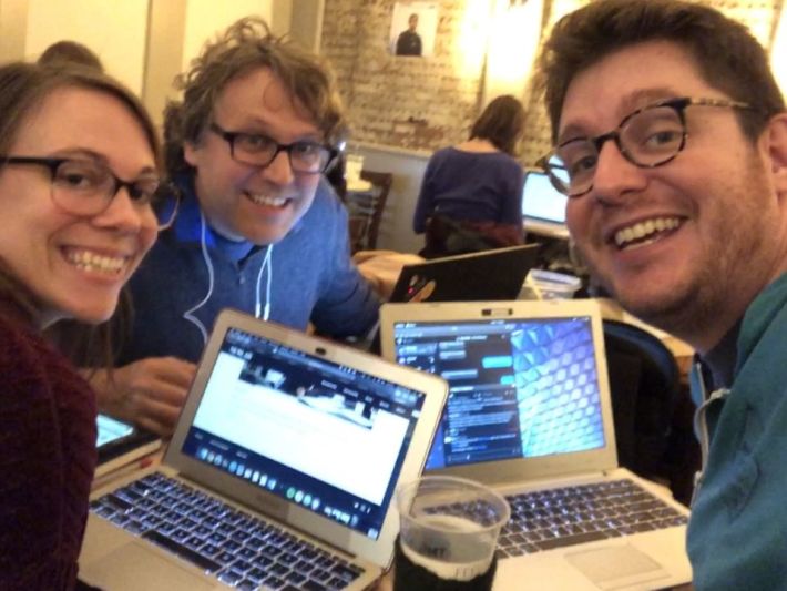tiaramiller.com, mfgriffin.com, and martymcgui.re smile at the camera, each leaning their laptops crowded close together on a small coffeeshop table.
