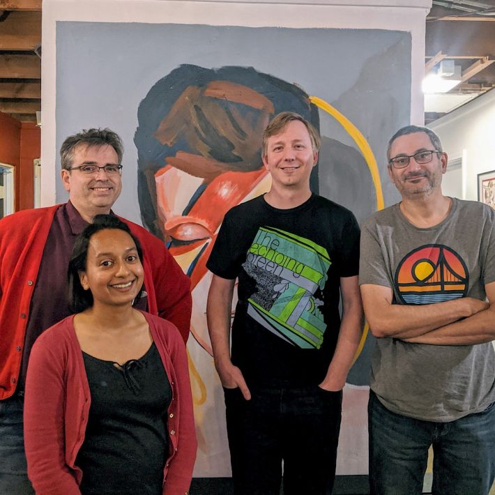 Joe, Suze, gRegor, and Simon in front of a painting of David Bowie as Ziggy Stardust