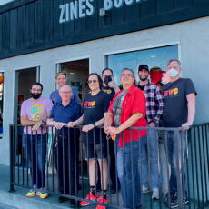 8 people standing in front of a storefront.