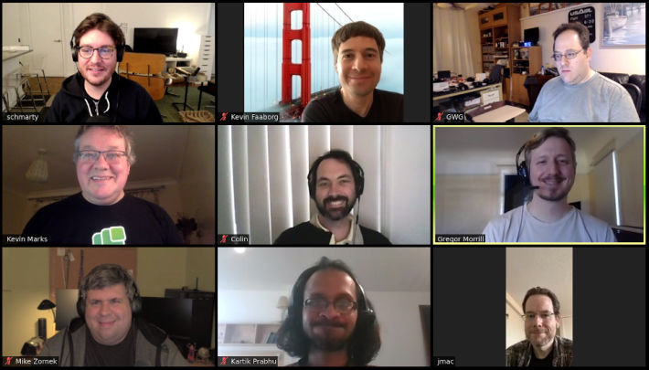 9 smiling faces in a Zoom meeting grid.