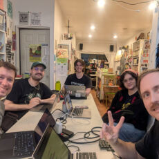 5 people around a table with their laptops 5 people around a table with their laptops