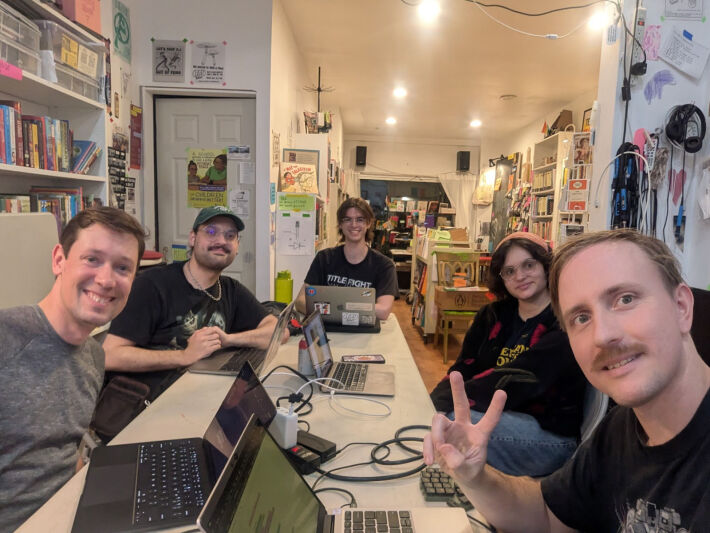 5 people around a table with their laptops 5 people around a table with their laptops
