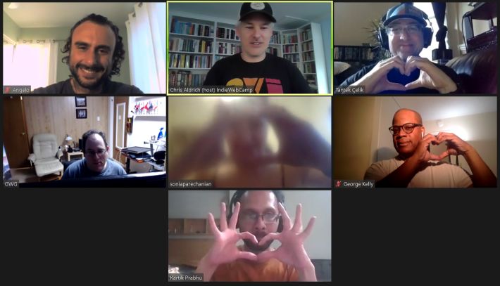 Seven attendees in a screen capture photo from Zoom. Many are making a heart shape with their hands because they love the IndieWeb.